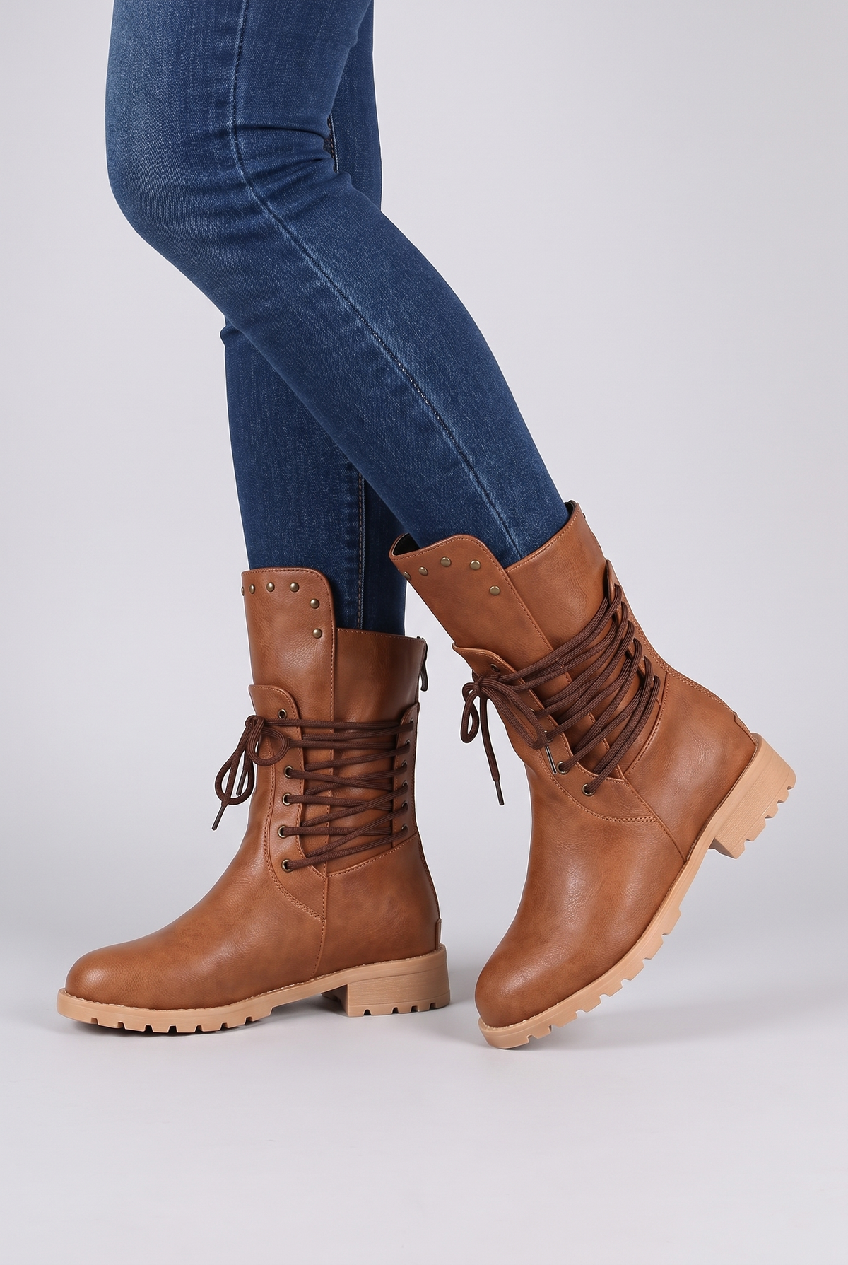 NOLA model wearing lace-up mid-calf boots lug sole studded